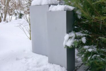 Schneebedeckte Pflanzkübel in einem Garten